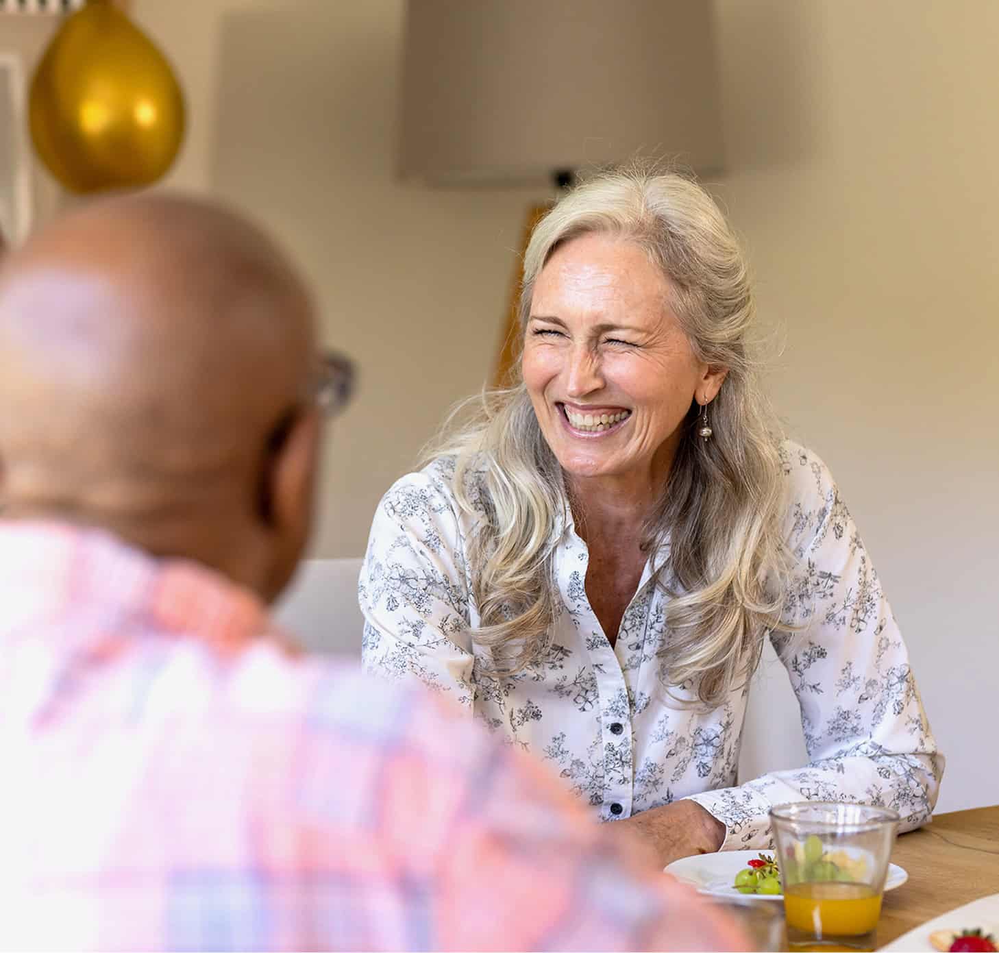 Elderly woman smiling during a friendly conversation at Seava Nest.