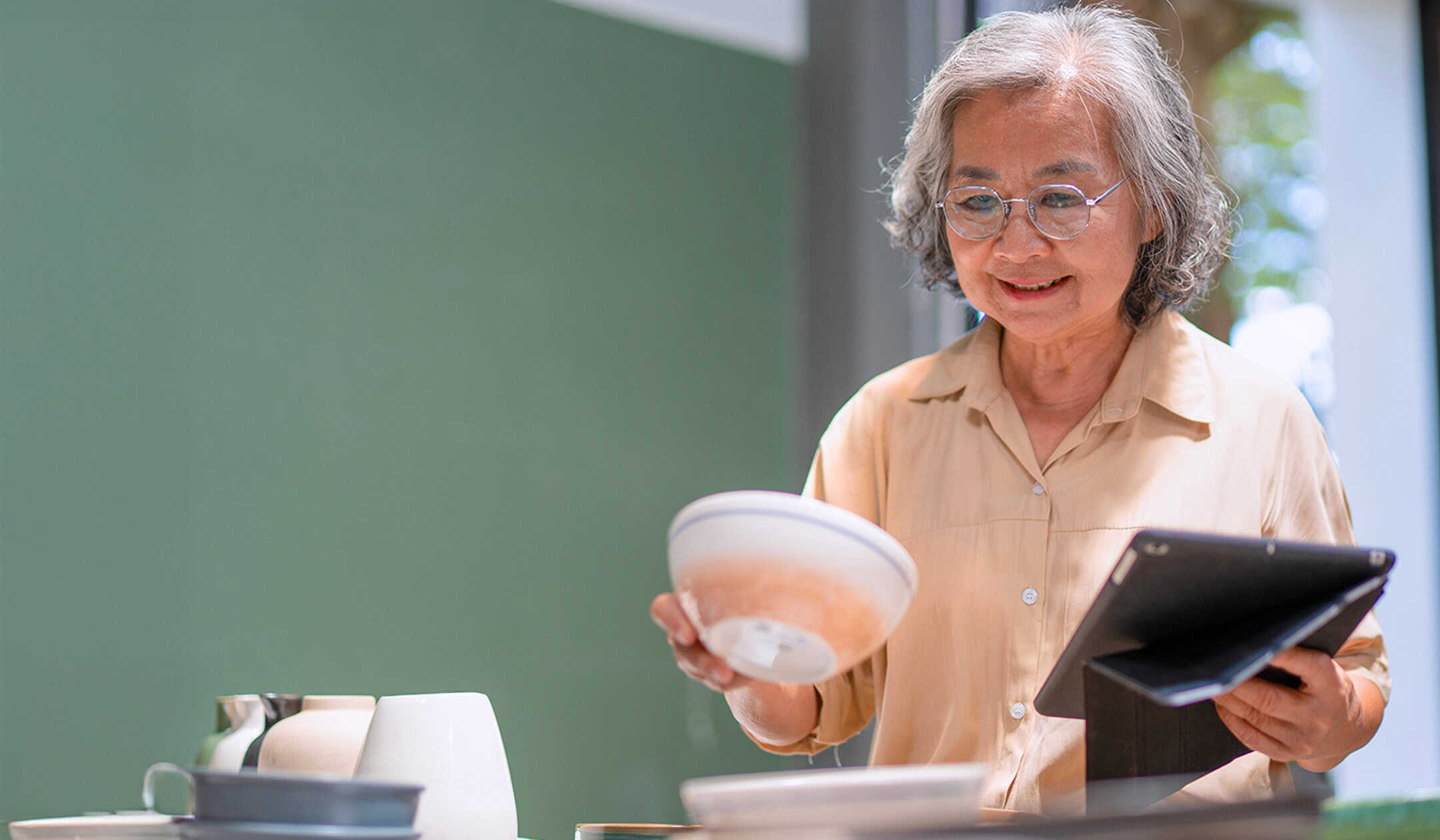 Elderly woman exploring options for new homes, smiling and holding a bowl, in a welcoming environmen.