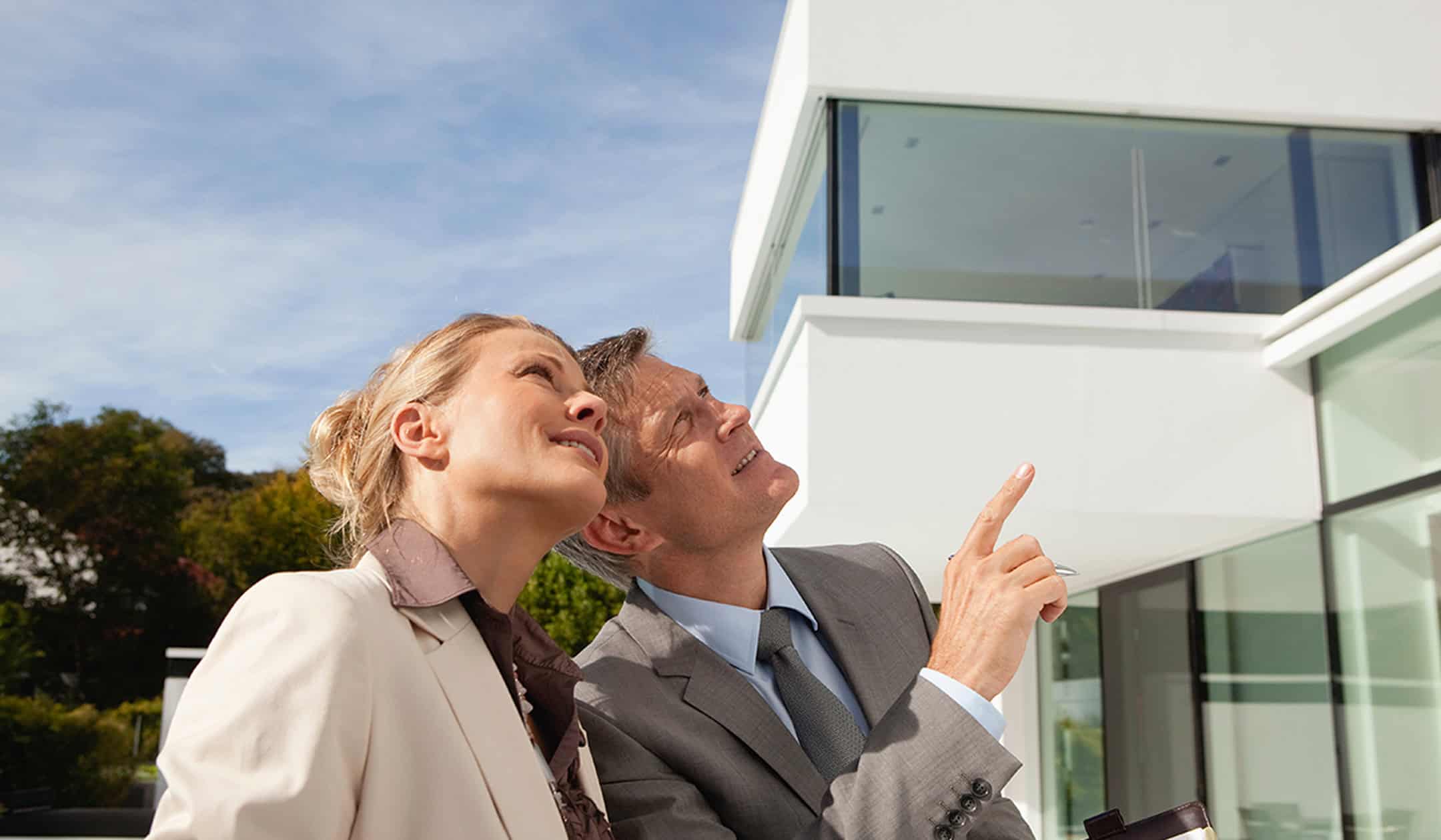Appraisal / valuation: professionals discussing property value outside a modern building.